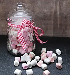 Jar of marshmallows with some spilled out